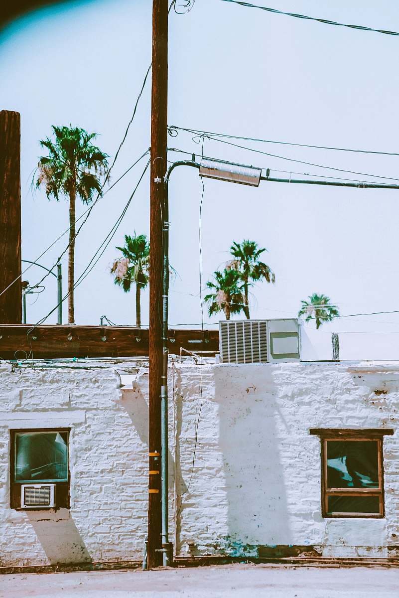 joshua tree white concrete building with green window utility pole